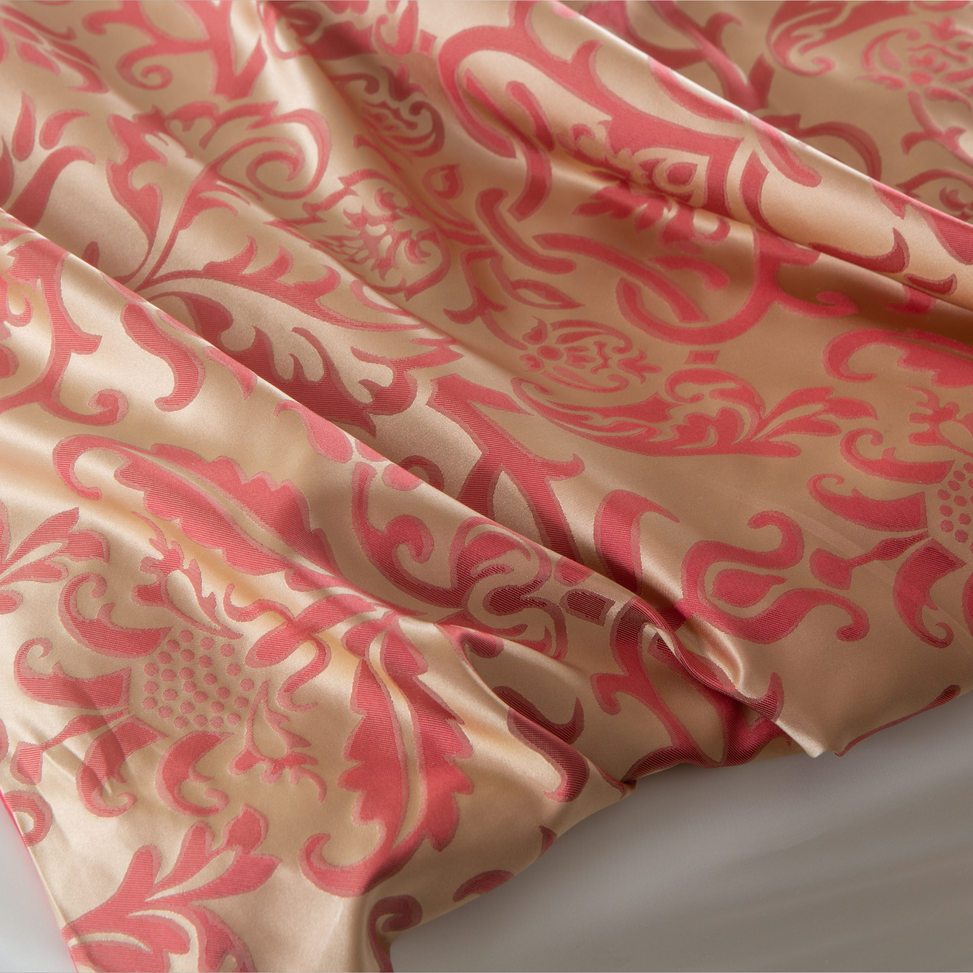 Detail des goldenen Jacquard-Musters auf glänzender Maulbeerseide