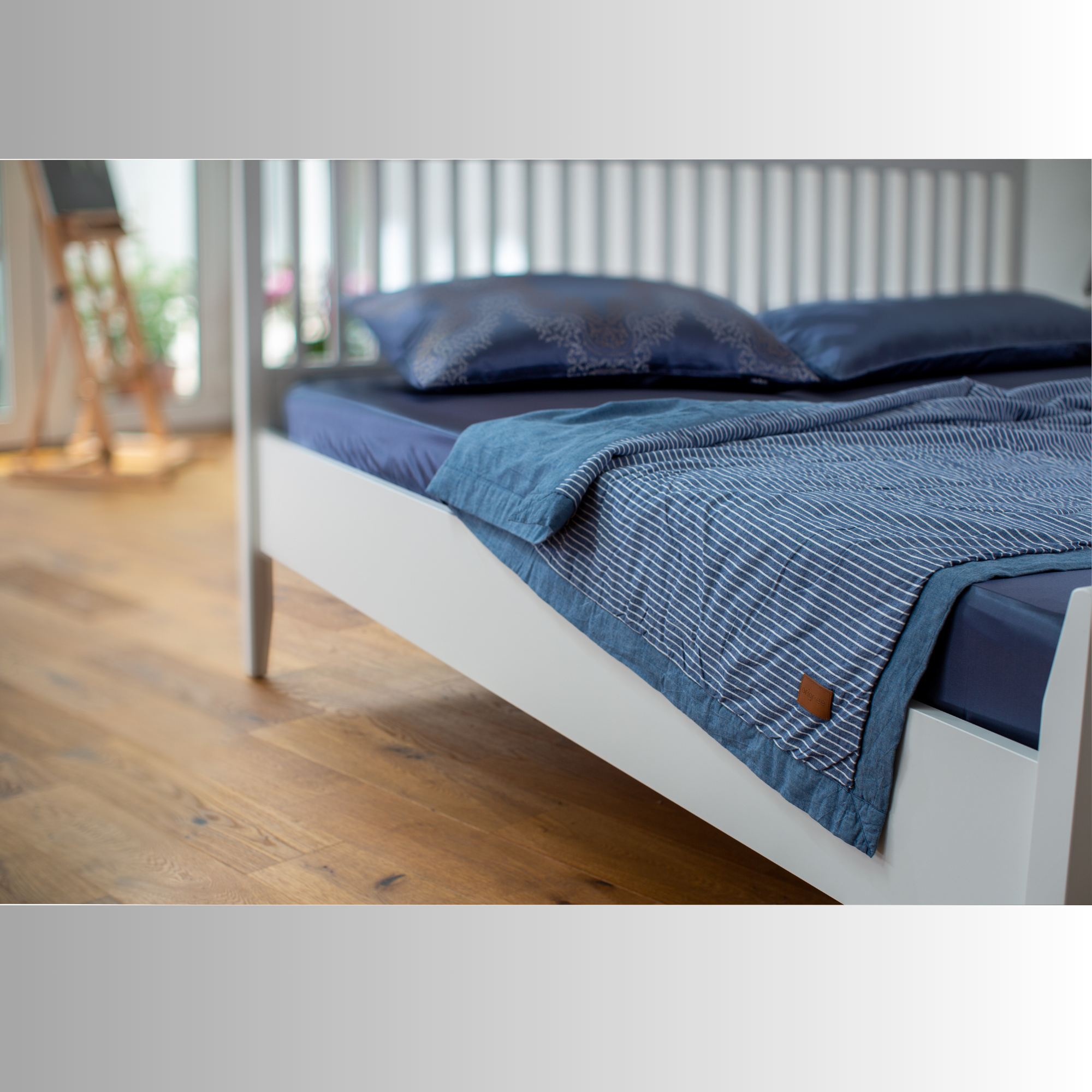 Shabby-Chic Seiden-Decke drapiert auf weißem Sofa – natürliche Falten & Lichtspiel